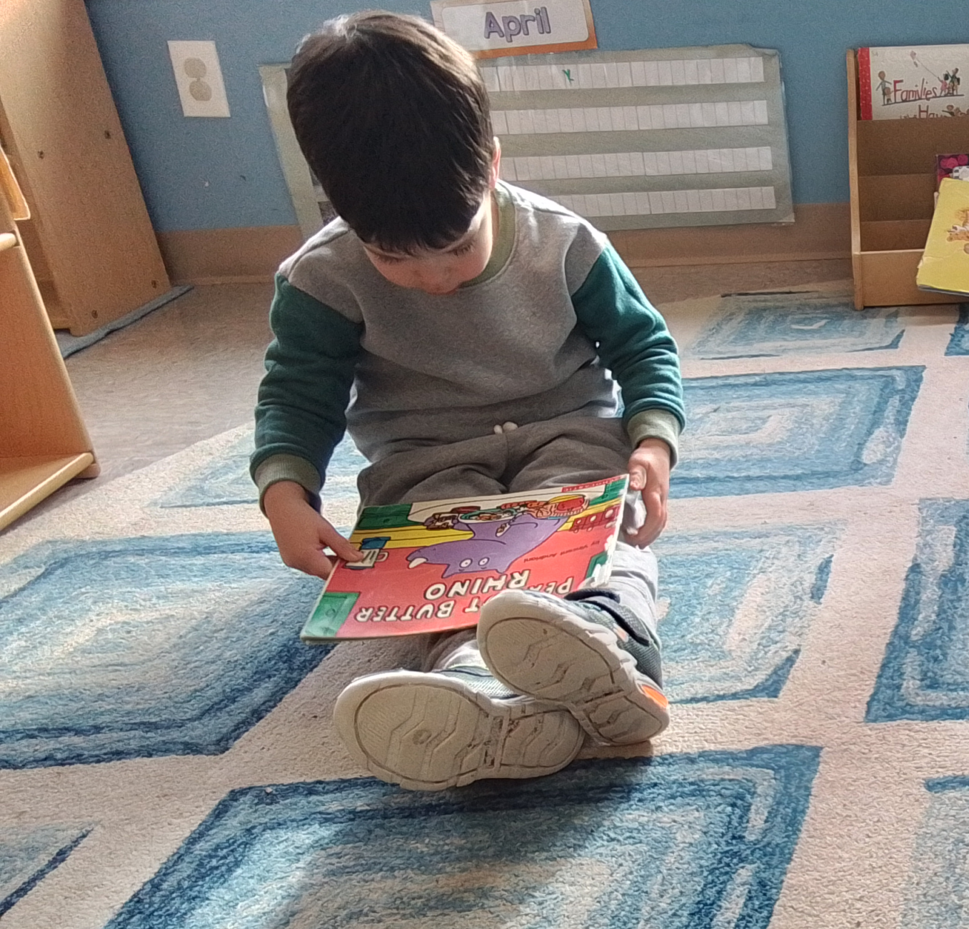 Boy reads a book on the floor